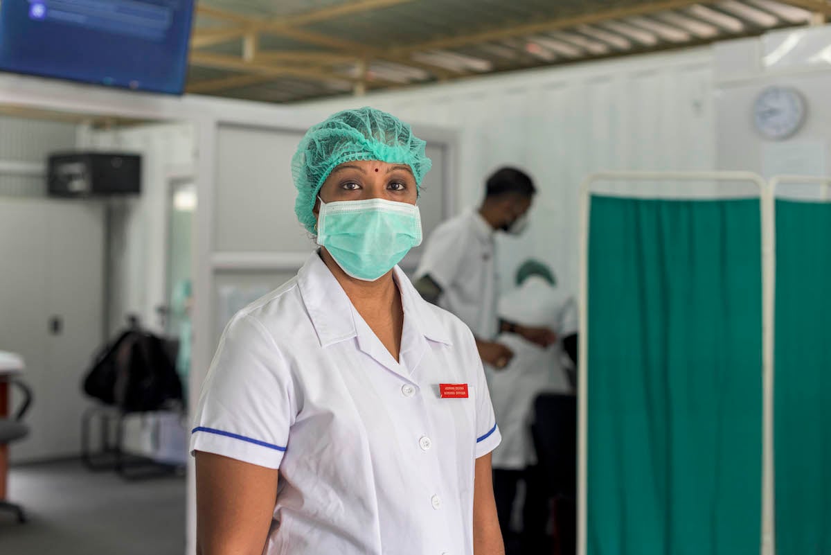 Female health worker in medical mask and haircover Female health worker in medical mask and haircover